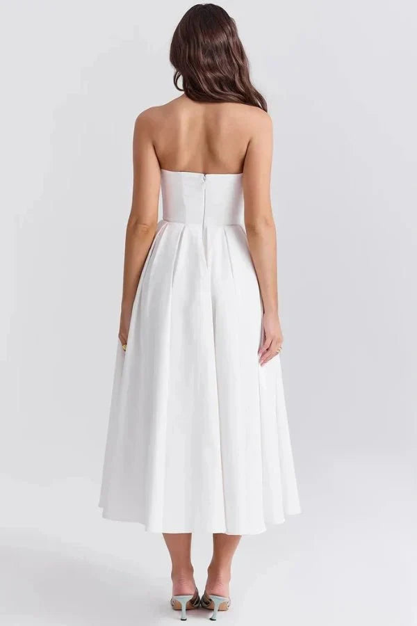Back view of a white strapless midi dress, showcasing the fitted bodice with a zipper and pleated A-line skirt.