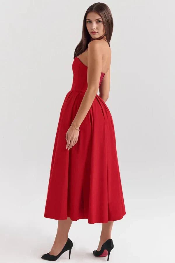 Side view of a vibrant red strapless midi dress with a full skirt, styled with black high heels, a bold dress suit for women.