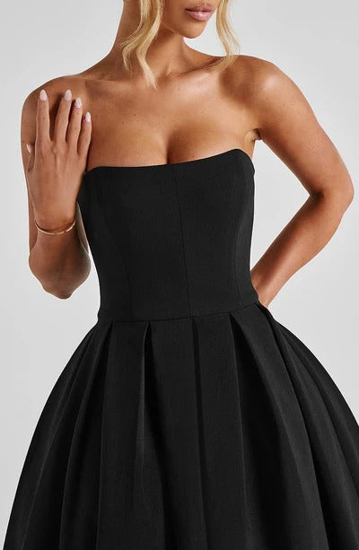 Close-up of the black strapless midi dress bodice, showing the sweetheart neckline and pleats.