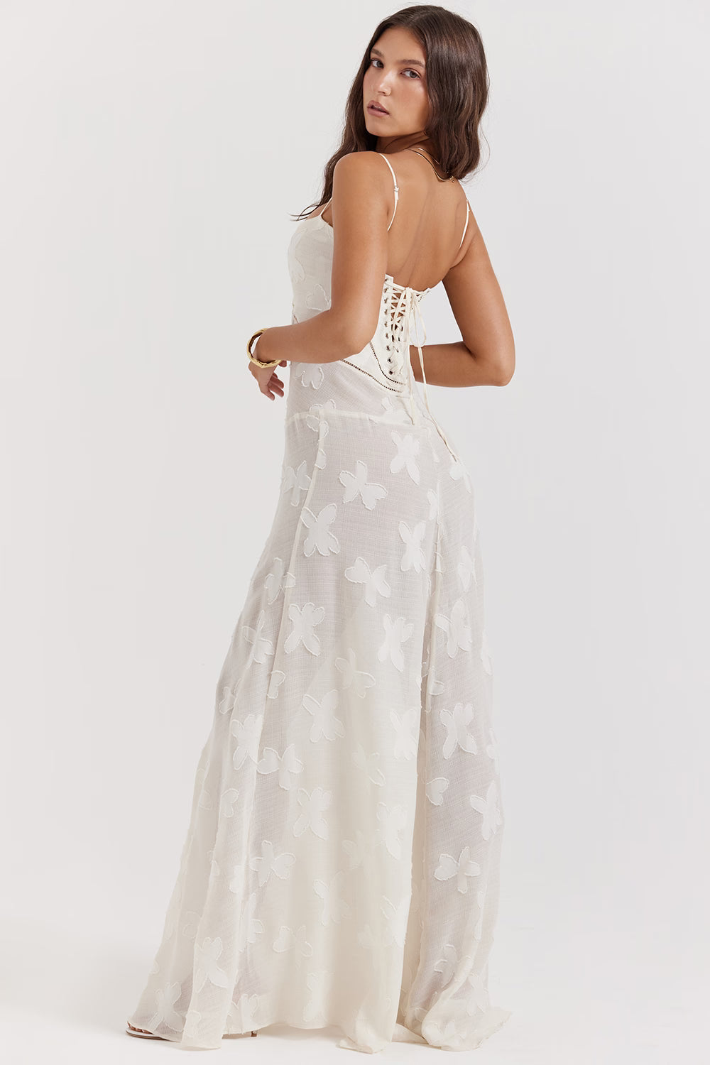 Back view of a white Juliet Lace Maxi Dress with delicate butterfly embroidery and a corset-style lace-up back.