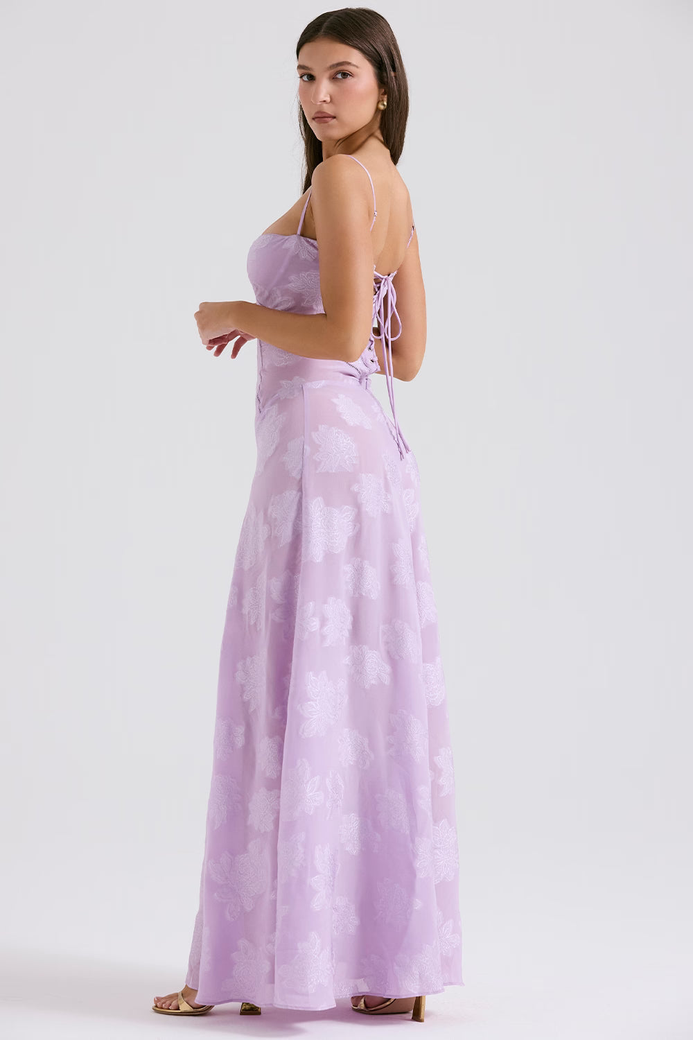 Side view of a lavender Juliet Lace Maxi Dress showcasing the lace-up corset back detail and flowing skirt with floral design.