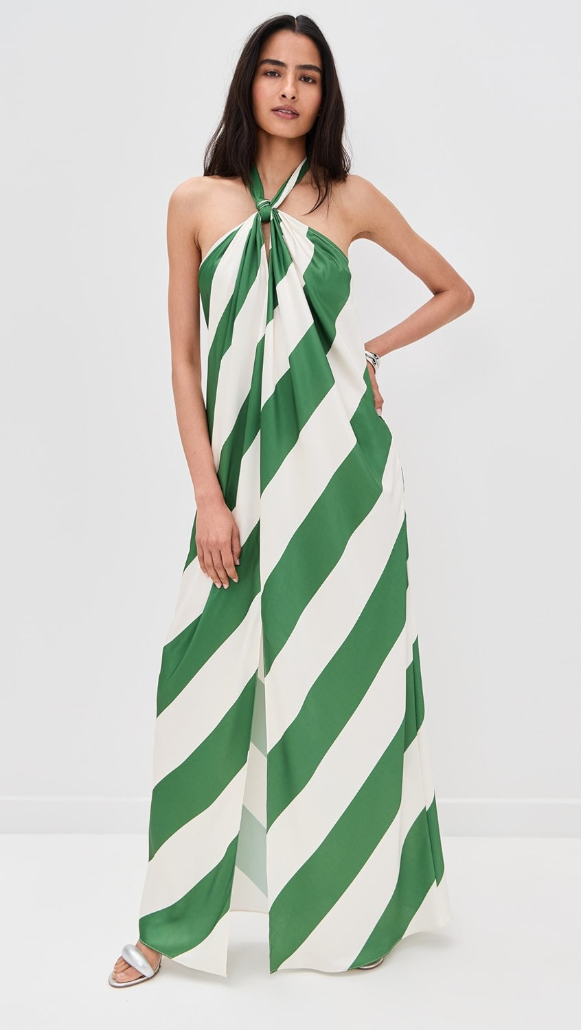 Full-length June Stripe Maxi Dress in green and white with halter neckline and front slit, paired with a cream clutch.