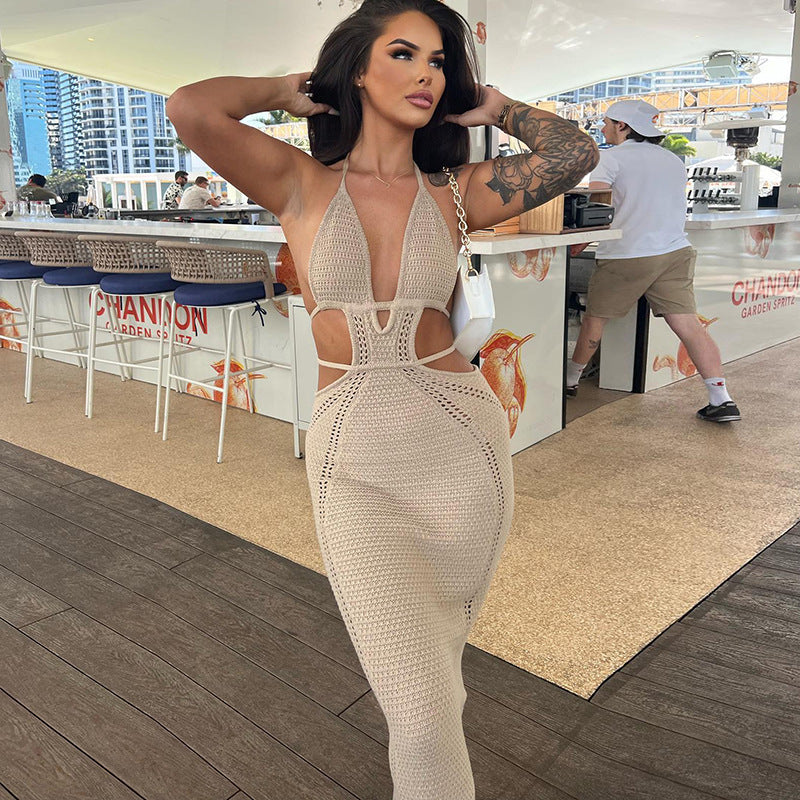 Beige Kara Cutout Maxi Dress with a halter neckline and detailed side cutouts, worn in an outdoor setting with a bar in the background.