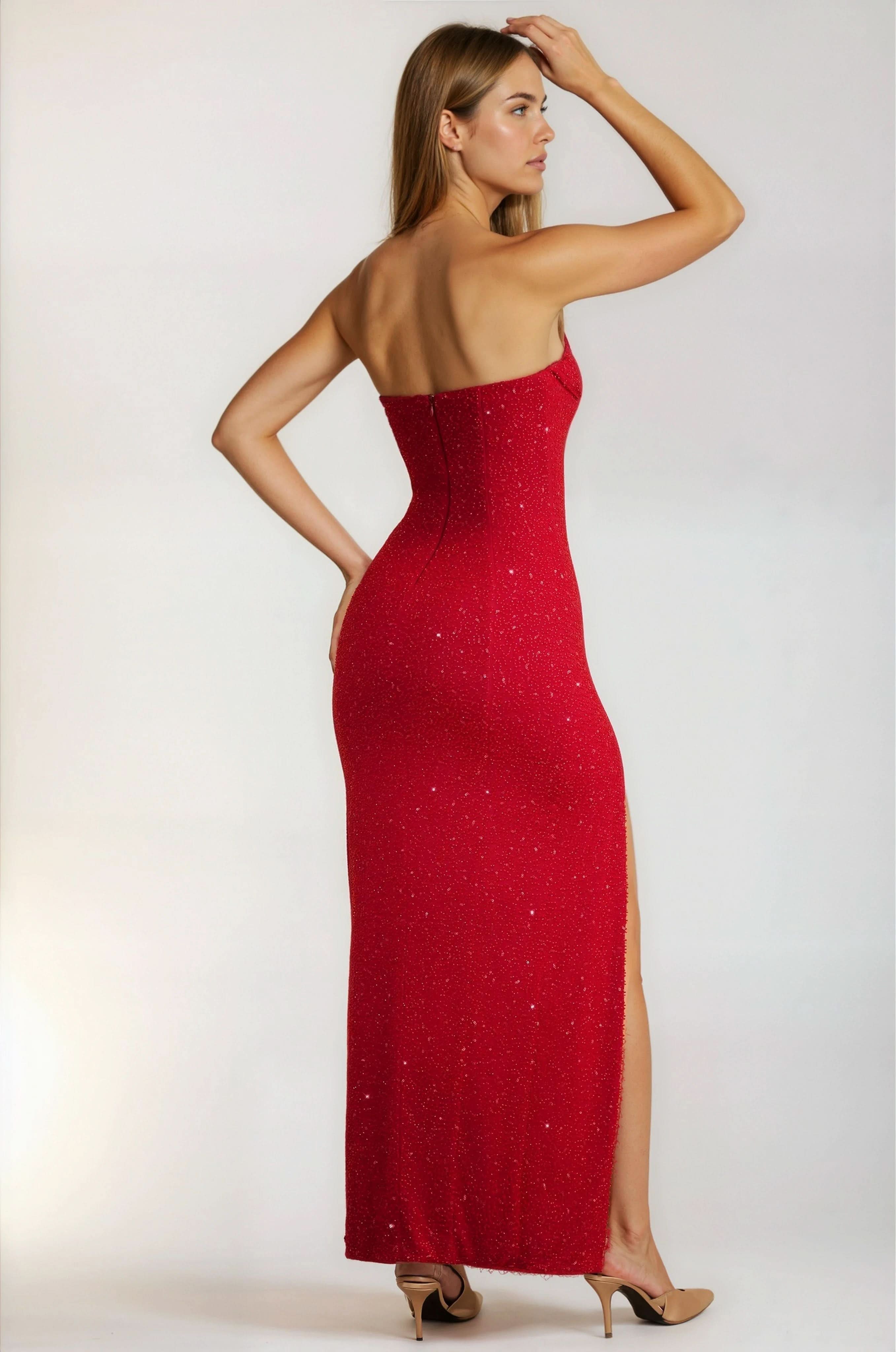 Back view of a red sequin strapless maxi dress, showing the fitted silhouette and high slit detail.