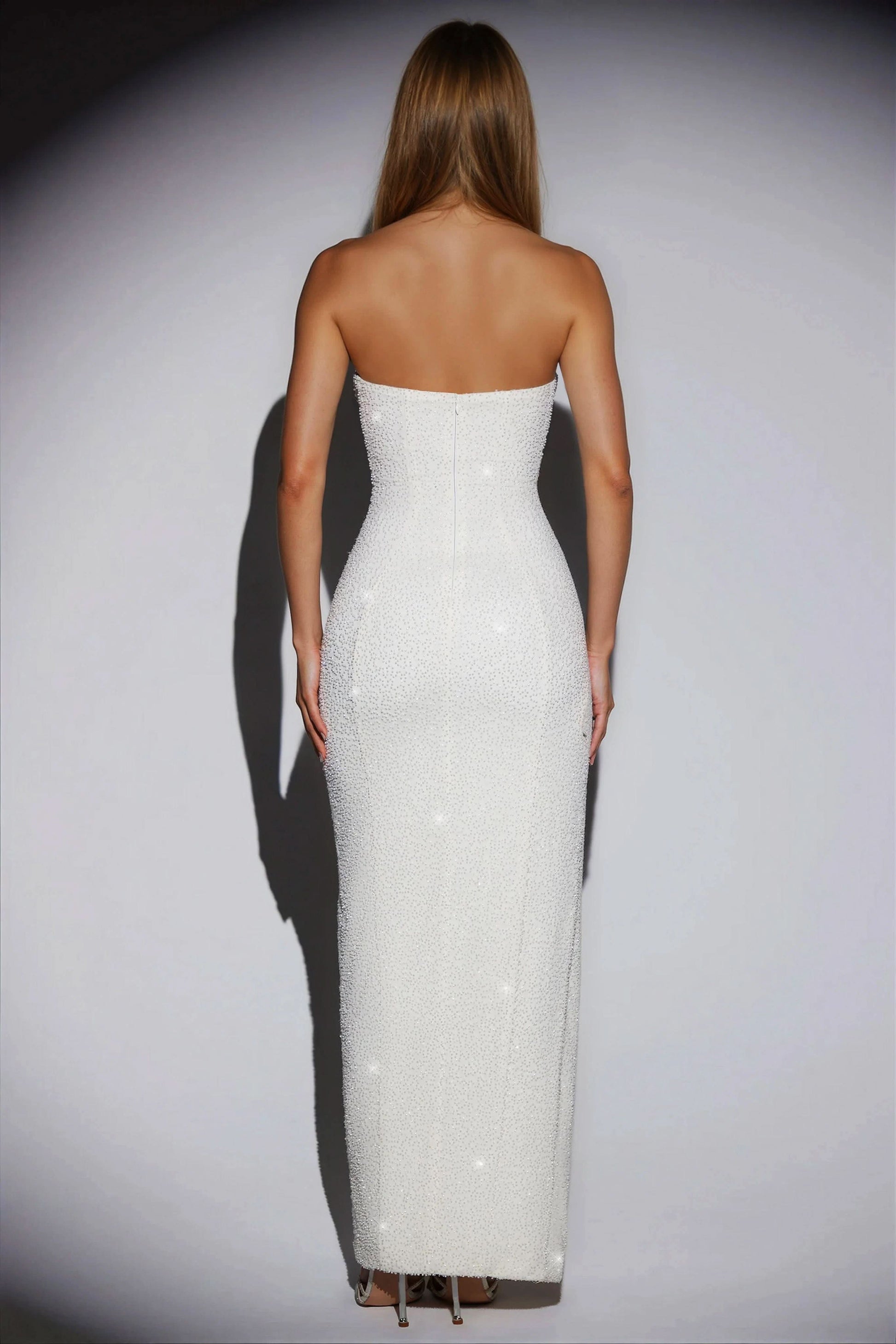 Back view of the white sequin strapless maxi dress, showing the full length and sparkling fabric.