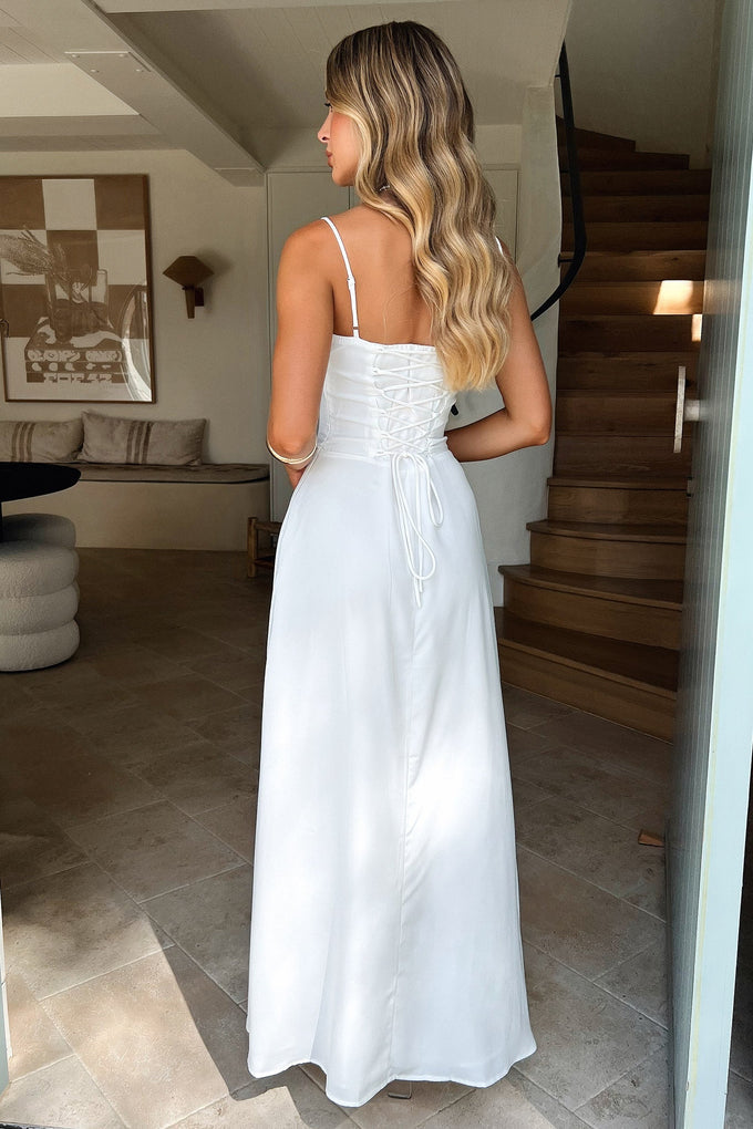 Back view of the elegant white Kora Ruched Maxi Dress, featuring a delicate lace-up back closure.