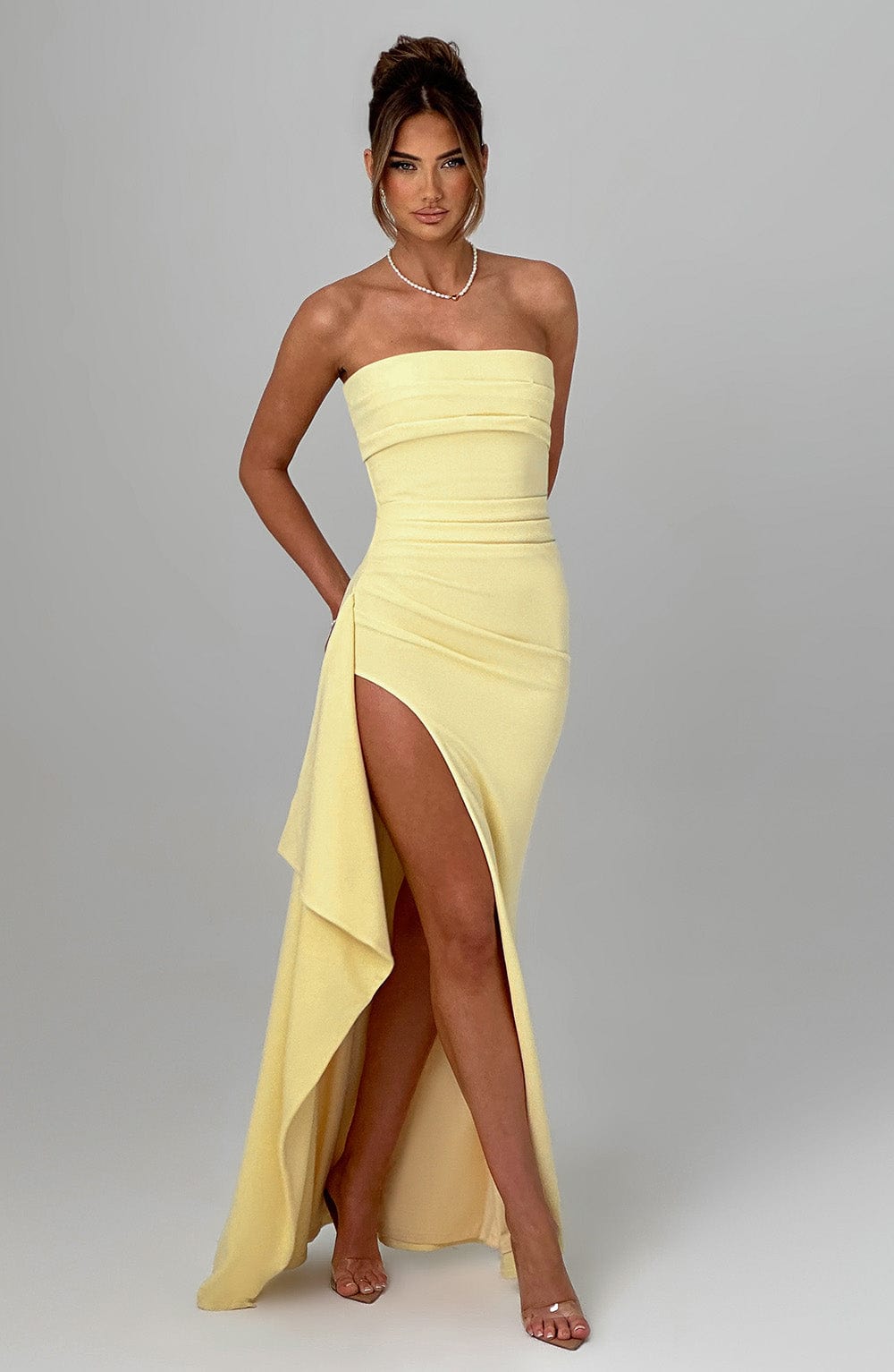 Front view of the Kyla Draped Maxi Dress in pale yellow, featuring a strapless design, ruched top, and an elegant side slit.