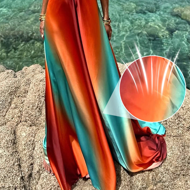 Detail shot of the Kylie Cutout Maxi Dress fabric, showcasing the vibrant orange, red, and blue ombre colors and soft texture, with a magnified breathable fabric detail.