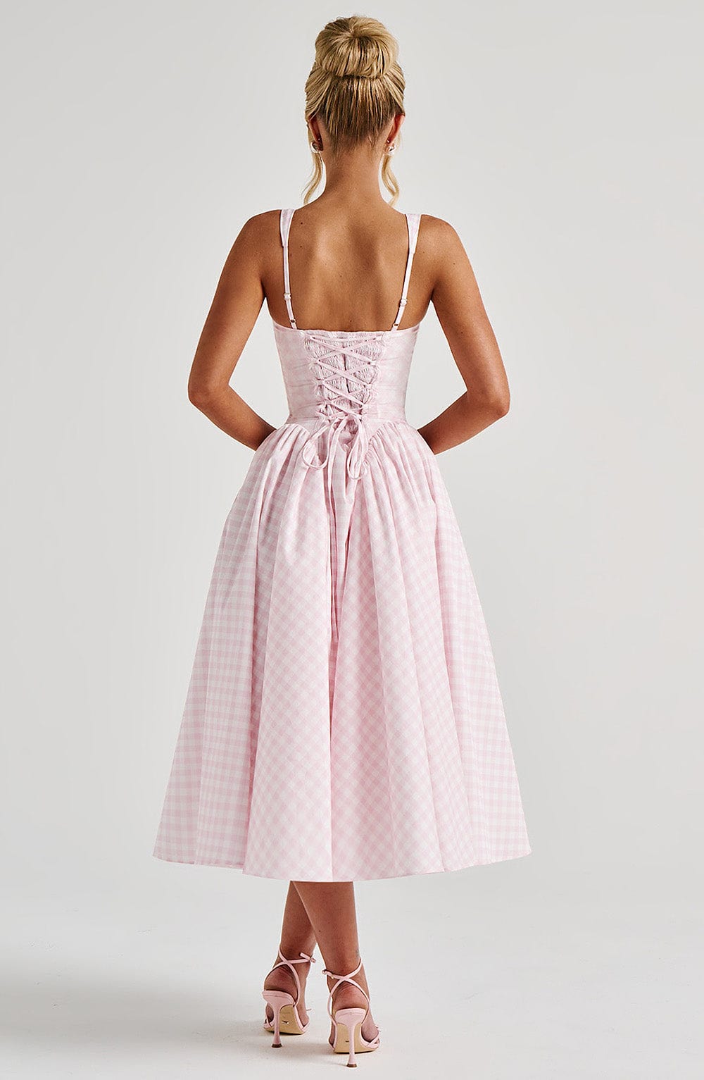 Back view of the pink gingham Lana Midi Dress, showcasing the corset-style lace-up detailing on the bodice.