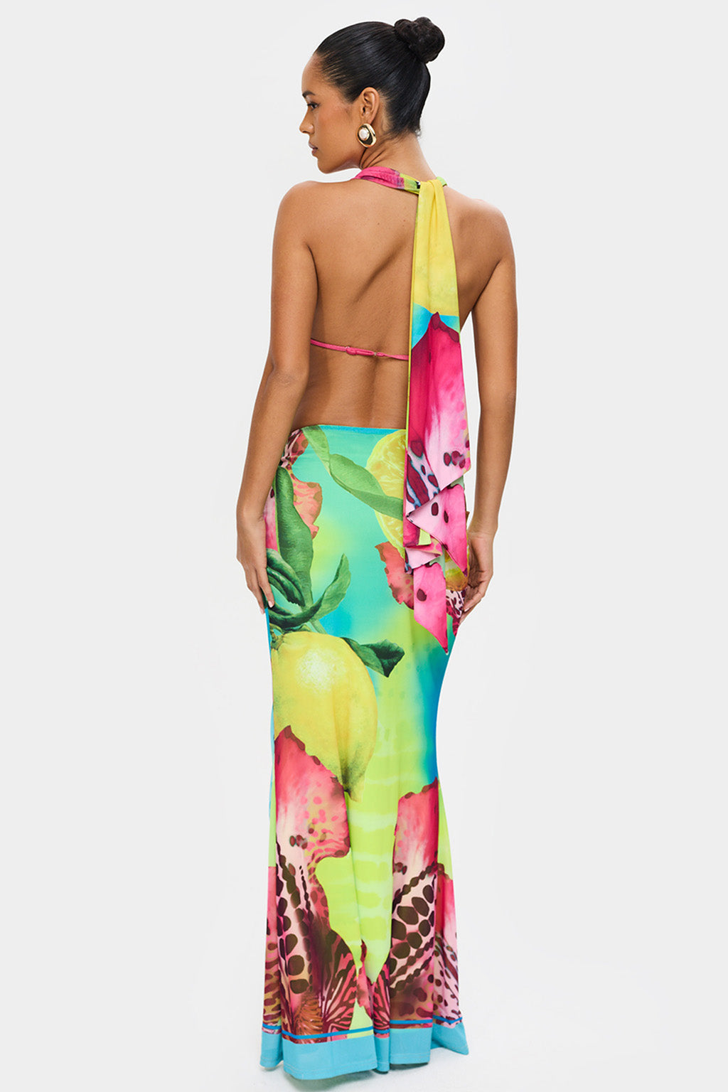Back view of a cowl neck top with tie-back detail and multi-color tropical print maxi skirt for women
