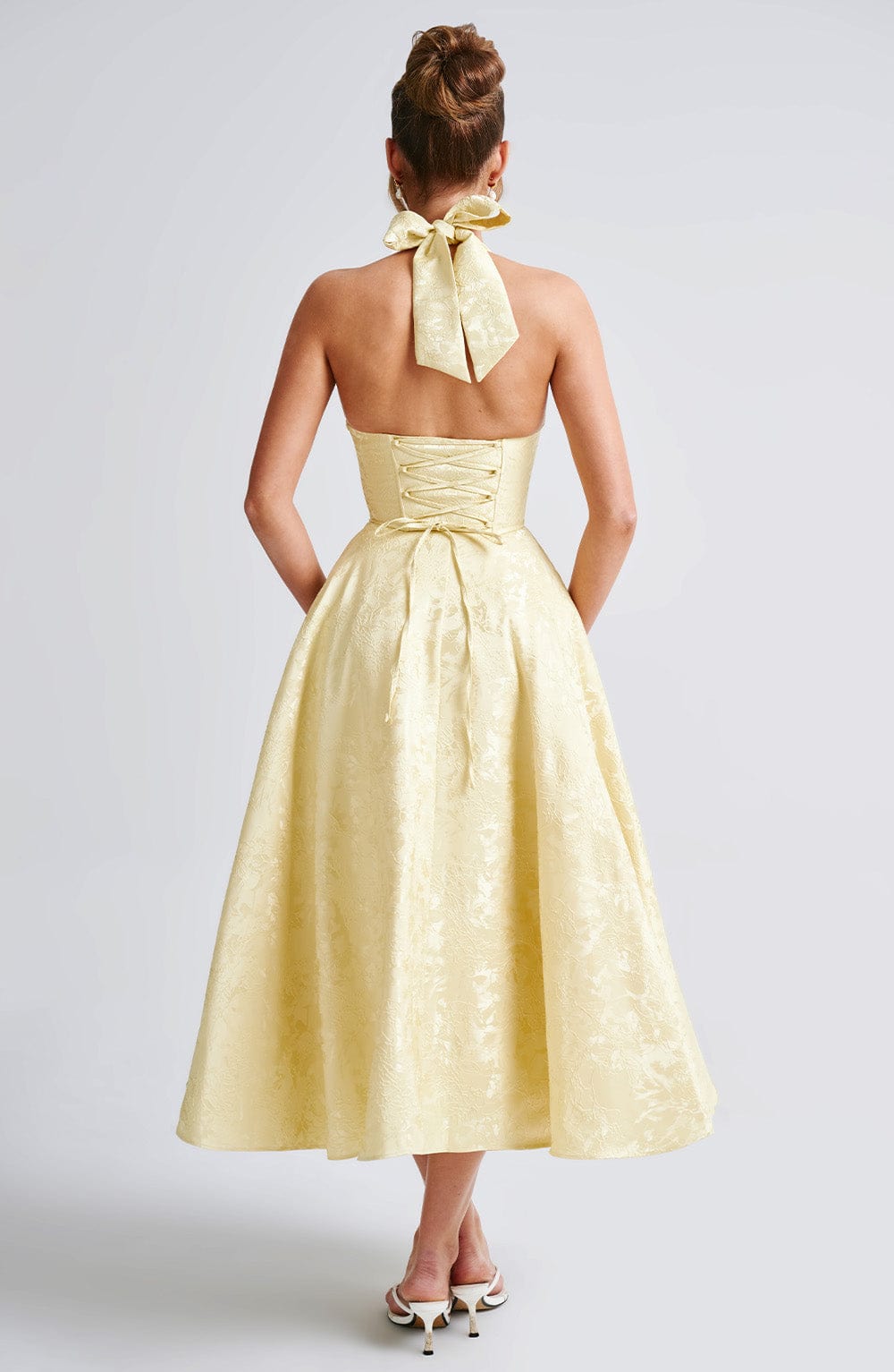 Back view of the yellow Leilani halter midi dress, featuring a tie-neck and corset-style lace-up back.