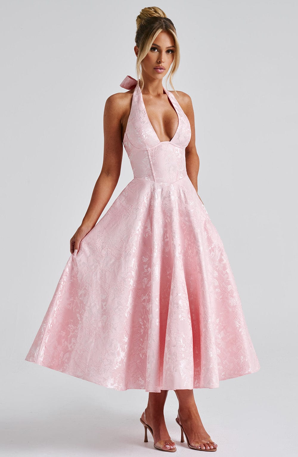 Front view of the Leilani halter midi dress in light pink, with a deep V-neck and a full, textured skirt.
