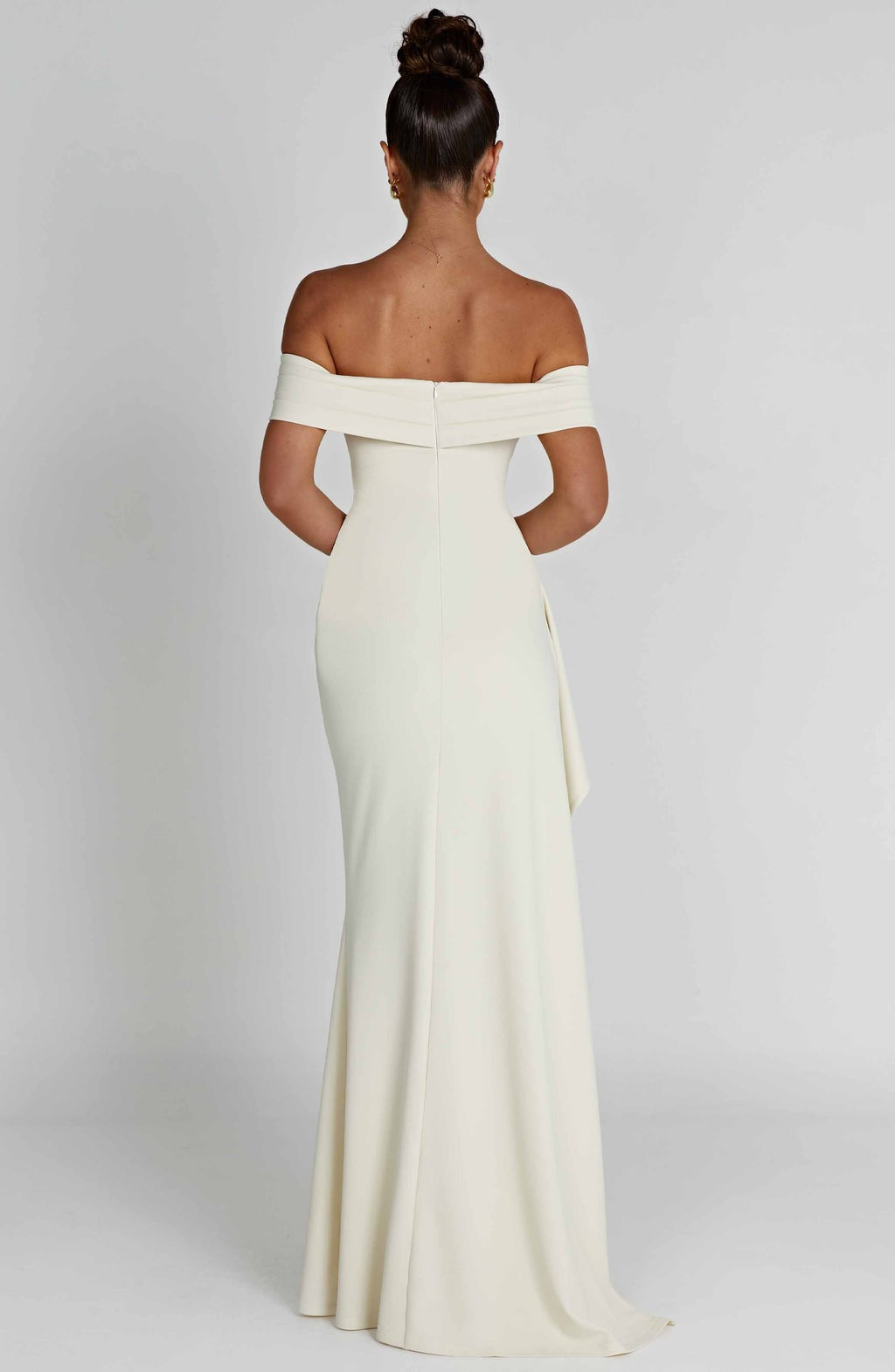 Back view of an off-white Leslie Bardot Maxi Dress with an off-the-shoulder neckline and a flowing skirt.