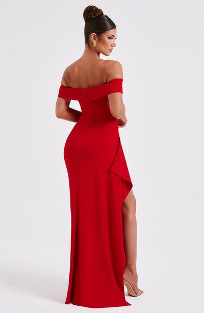 Back 3/4 view of a red Leslie Bardot Maxi Dress featuring an off-the-shoulder design and a high slit.