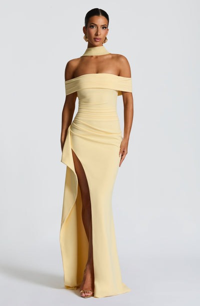 Front view of a light yellow Leslie Bardot Maxi Dress with an off-the-shoulder design and a high slit.