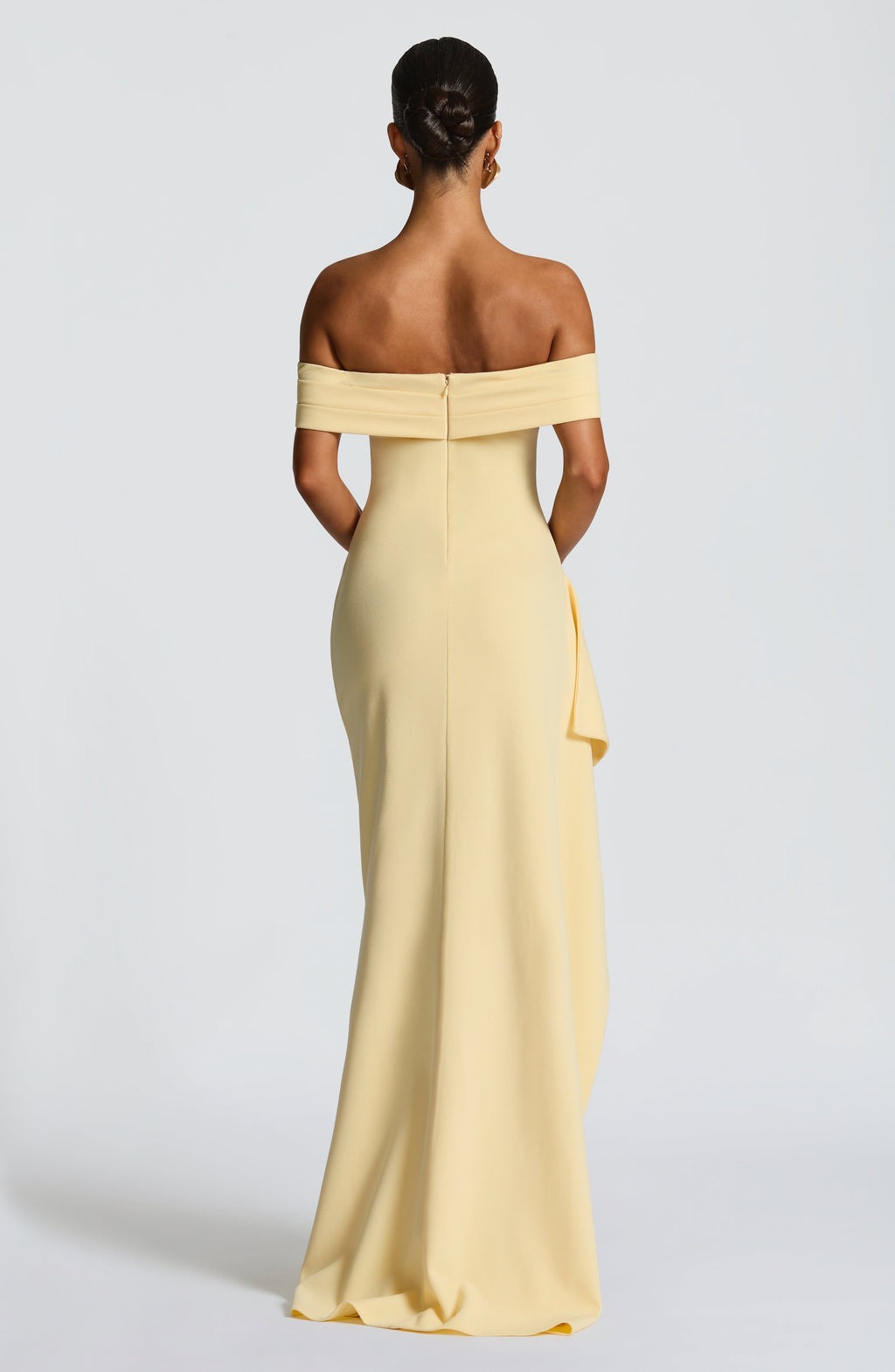 Back view of a light yellow Leslie Bardot Maxi Dress showcasing the off-the-shoulder neckline and long skirt.