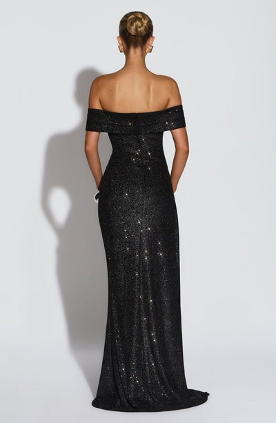 Back view of a shimmering black Leslie Bardot Maxi Dress with an off-the-shoulder neckline and floor-length skirt.