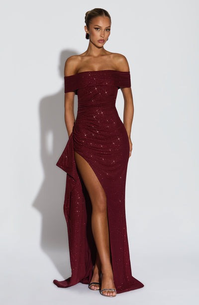 Full-length view of a sparkling burgundy off-the-shoulder maxi dress with a ruched bodice and high slit.