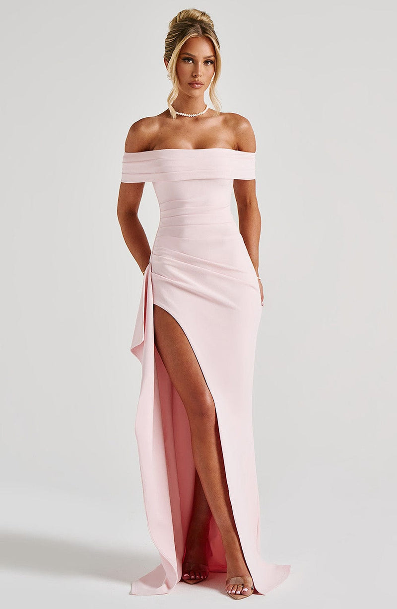 Full-length light pink off-the-shoulder maxi dress with a high slit and ruched bodice detail