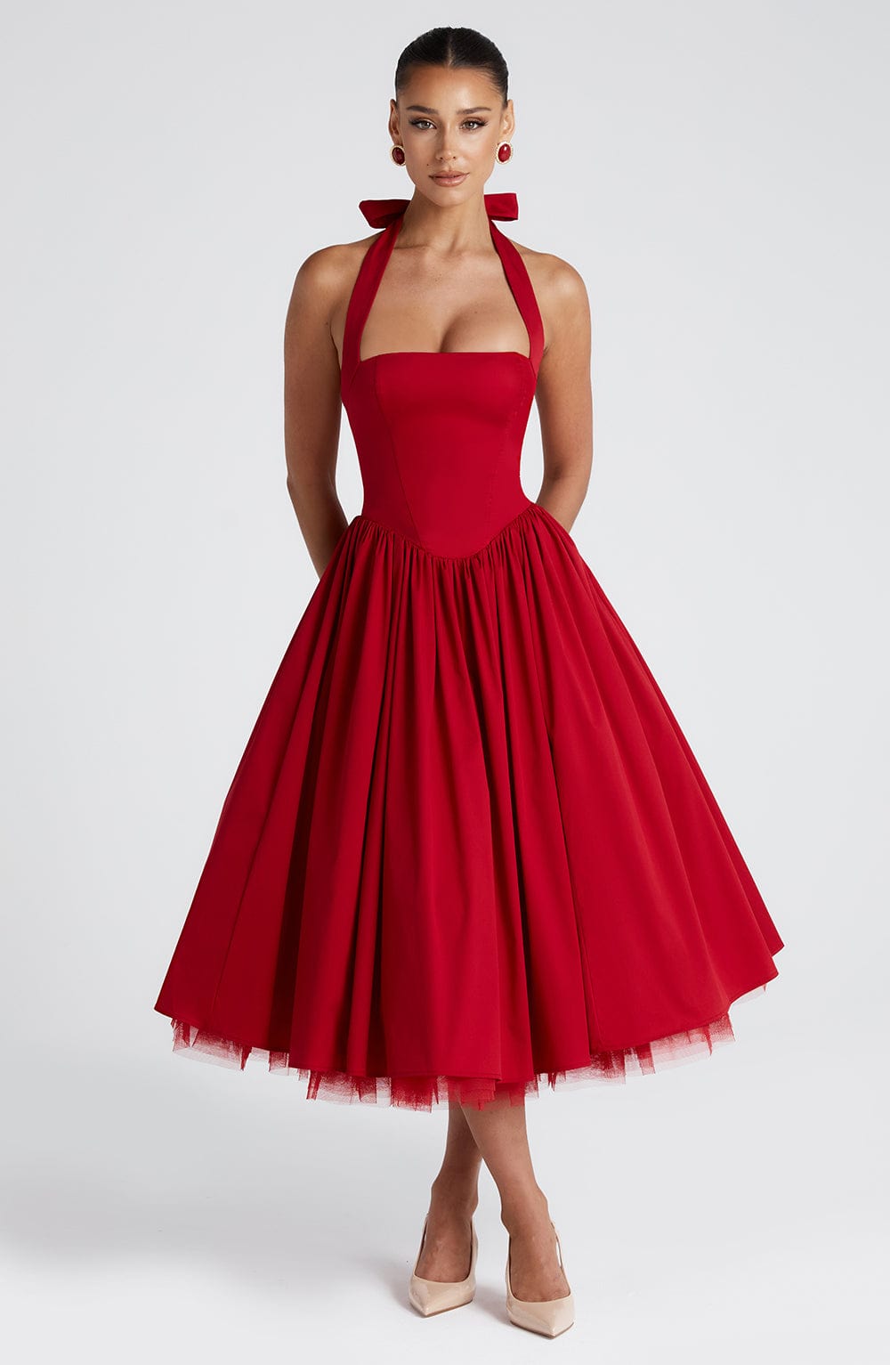 Front view of a red halter midi dress with a square neckline and a full pleated skirt, revealing a subtle tulle layer underneath.