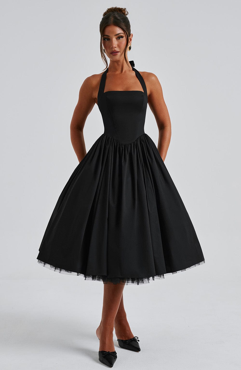 Front view of a black halter midi dress, featuring a structured bodice and a voluminous skirt.