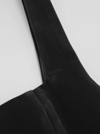 Close-up of the wide strap and square neckline detail of the black Lillie Bow Mini Dress, showing fabric texture.