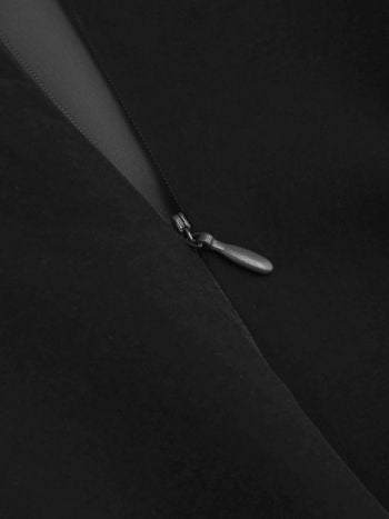 Detail of the hidden zipper on the side of the black Lillie Bow Mini Dress, with the zipper pull visible.