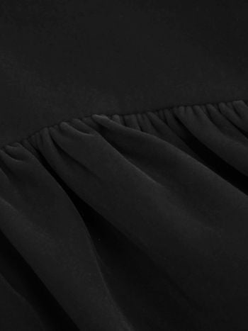 Close-up of the gathered skirt detail on the black Lillie Bow Mini Dress, showcasing the soft folds of the fabric.