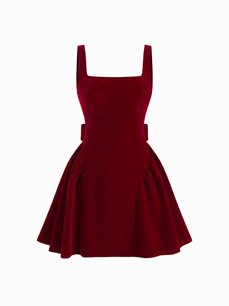 Front view of a Lillie Bow Mini Dress in deep red velvet, featuring a square neckline, thick straps, and pleated skirt details.