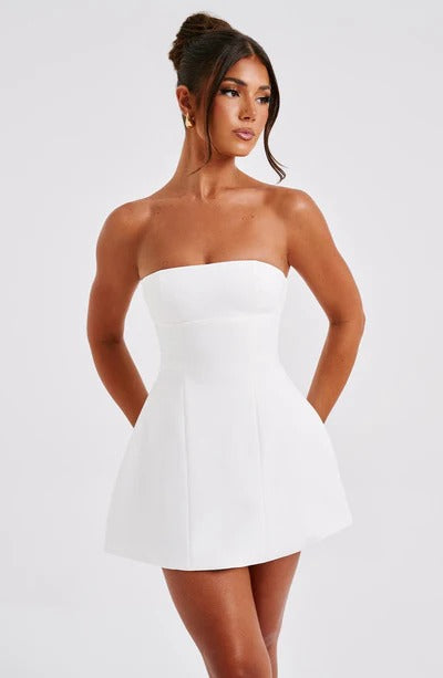 Front view of a woman wearing a white strapless Lola Bubble Mini Dress with a structured bodice and flared skirt.