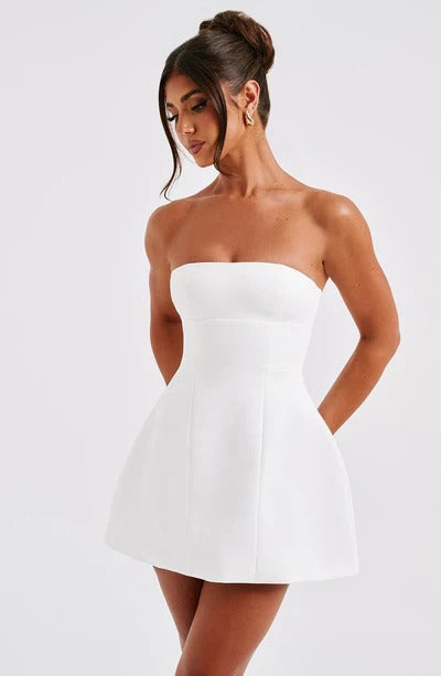 Side view of a woman in a white strapless Lola Bubble Mini Dress, showcasing the elegant fit and flare silhouette.