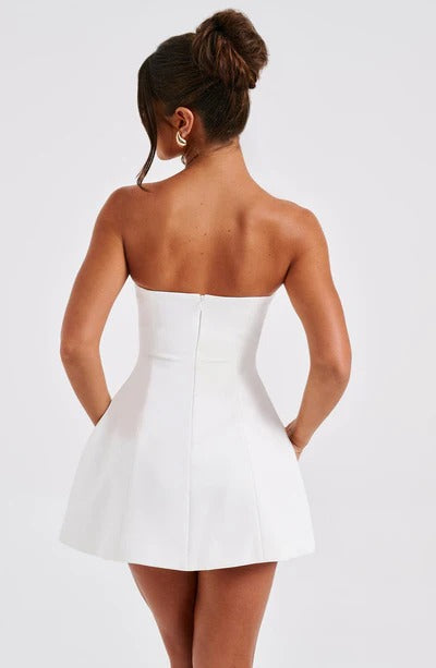 Back view of a woman wearing a white strapless Lola Bubble Mini Dress, highlighting the clean lines and concealed zipper.