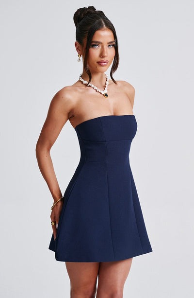Navy blue strapless mini dress with a fitted bodice and flared bubble skirt, perfect for a party or special occasion.