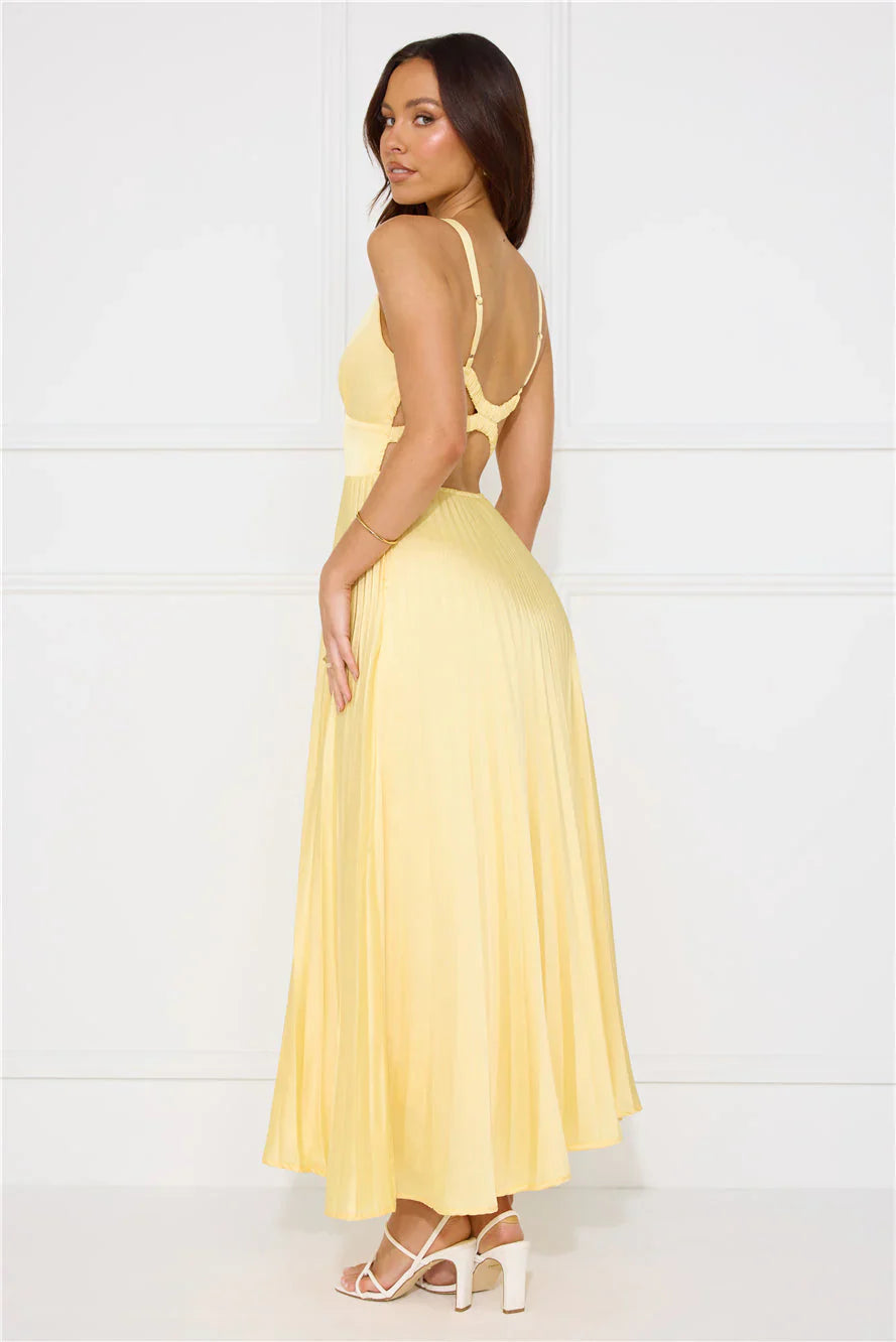 Side profile of a woman in a light yellow maxi dress, showing V-neck and cut-out back detail for women