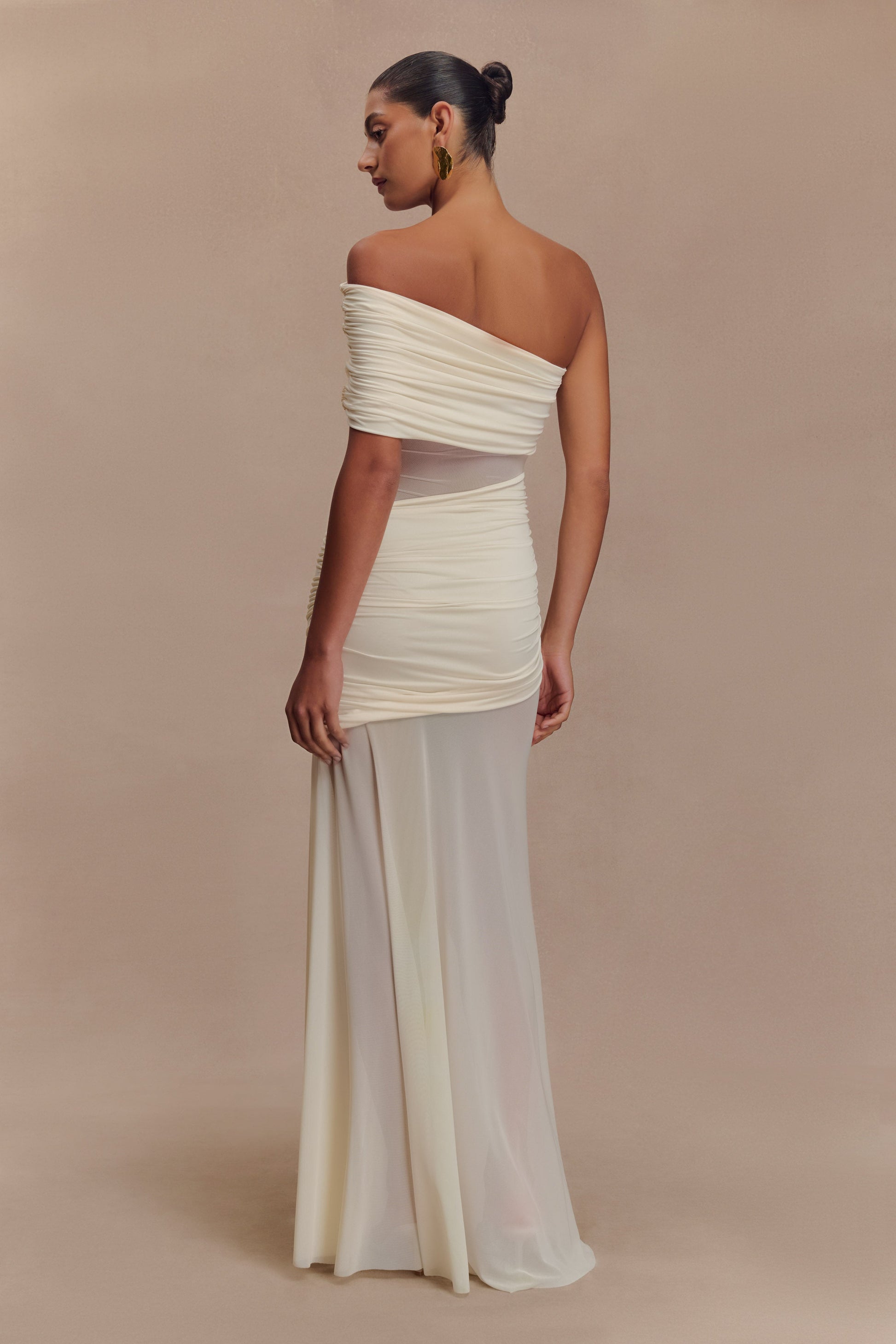 Back view of the ivory Luella cutout maxi dress, showing the elegant off-the-shoulder drape and sheer lower skirt.