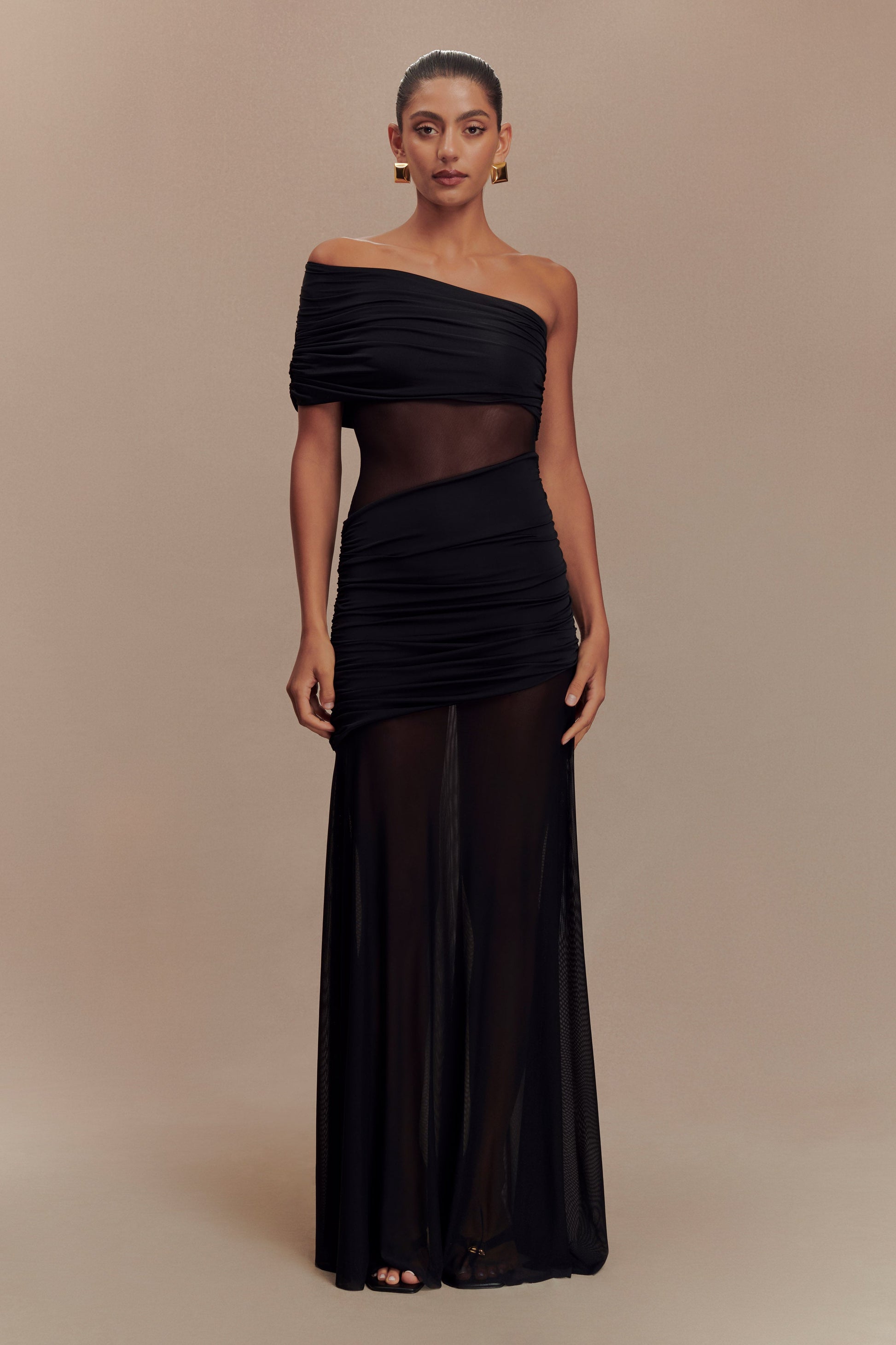 Full-length black Luella cutout maxi dress with sheer mesh panels and ruched off-the-shoulder design, front view.