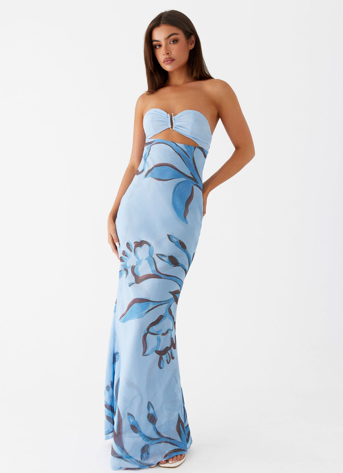 Lyra Floral Maxi Dress in yellow with strapless top, cutout waist, and white floral print, worn on rocky beach.