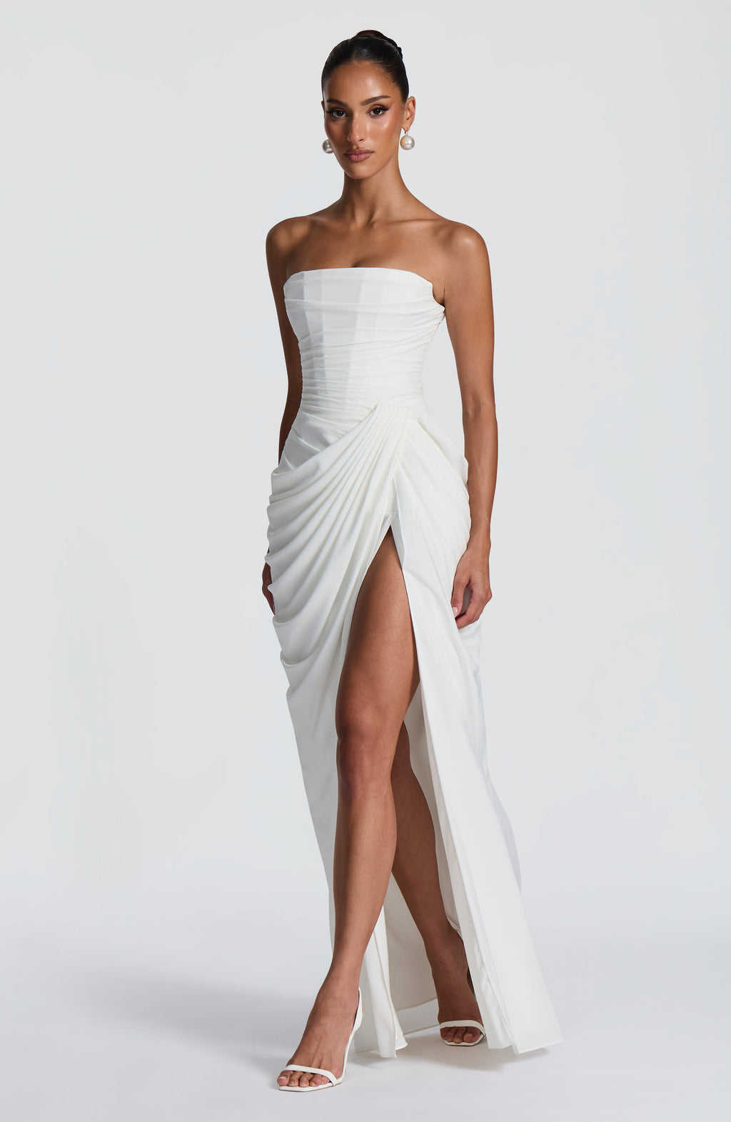 White strapless ruched maxi dress with draped wrap skirt and high slit, front view