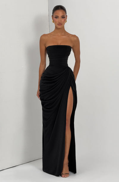 Black strapless ruched maxi dress with wrap drape and high slit, lifestyle studio corner