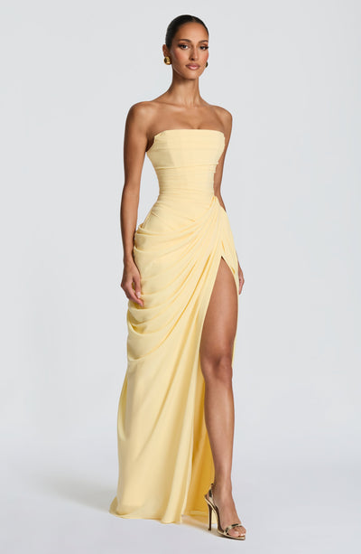 Pale yellow strapless ruched maxi dress with draped skirt and thigh-high slit angled view