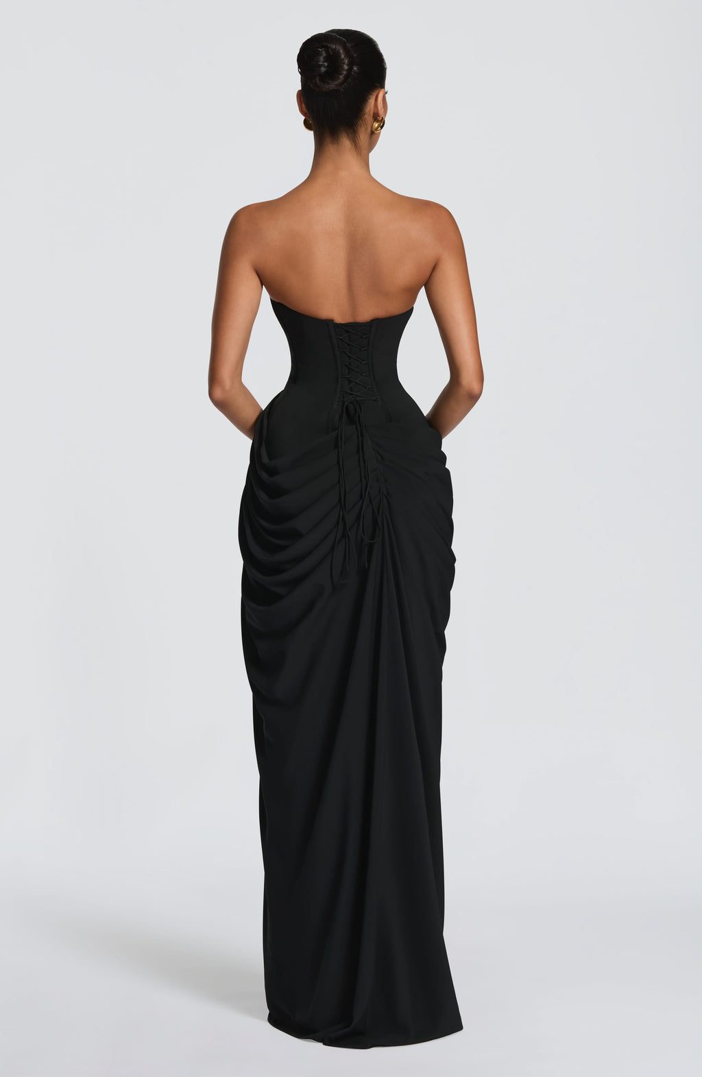 Back view black ruched maxi dress with strapless bodice, lace-up corset back, and draped ruching