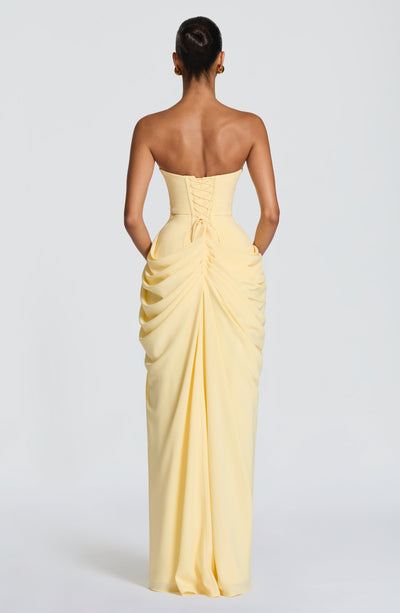 Back view of pale yellow ruched maxi dress with lace-up corset back and gathered skirt