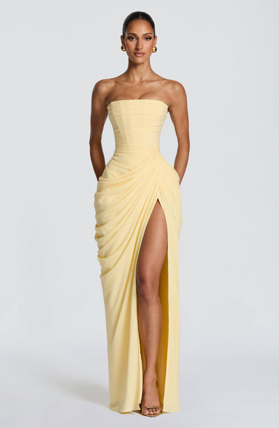 Pale yellow strapless ruched maxi dress with corset bodice and high slit front view