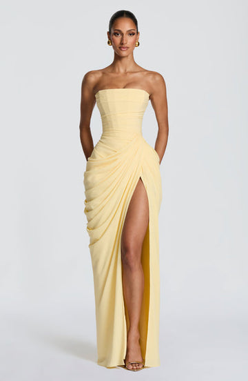 Pale yellow strapless ruched maxi dress with corset bodice and high slit front view