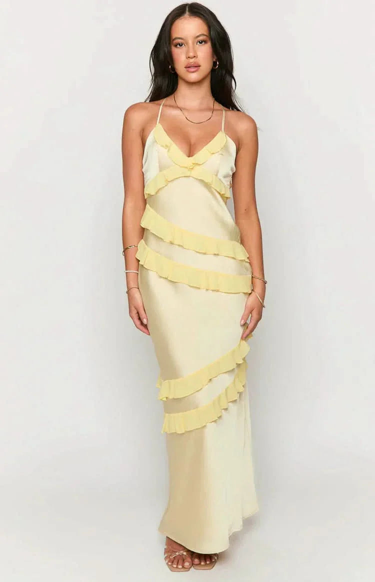 Pale yellow satin Madeline ruffle maxi dress with spaghetti straps and cascading ruffles on a light background.