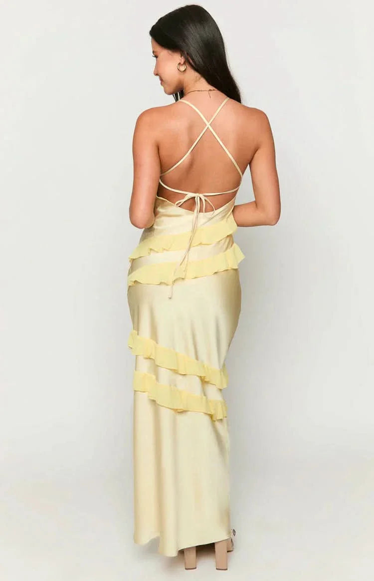 Back view of a pale yellow Madeline ruffle maxi dress, showing the criss-cross back straps and tiered ruffle design.