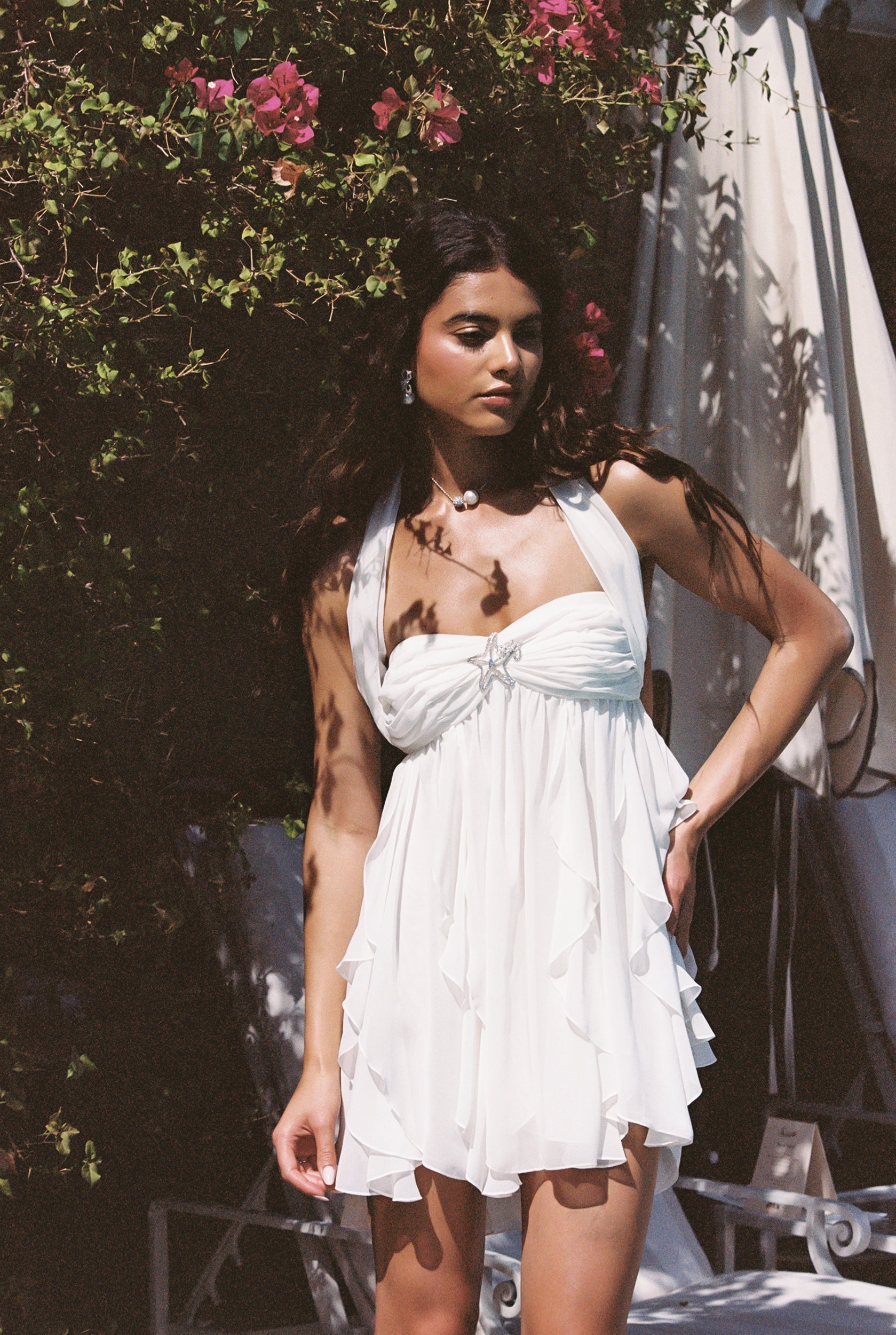 White Maeve Ruffle Mini Dress with a halter neckline, pleated bodice, and layered skirt details.