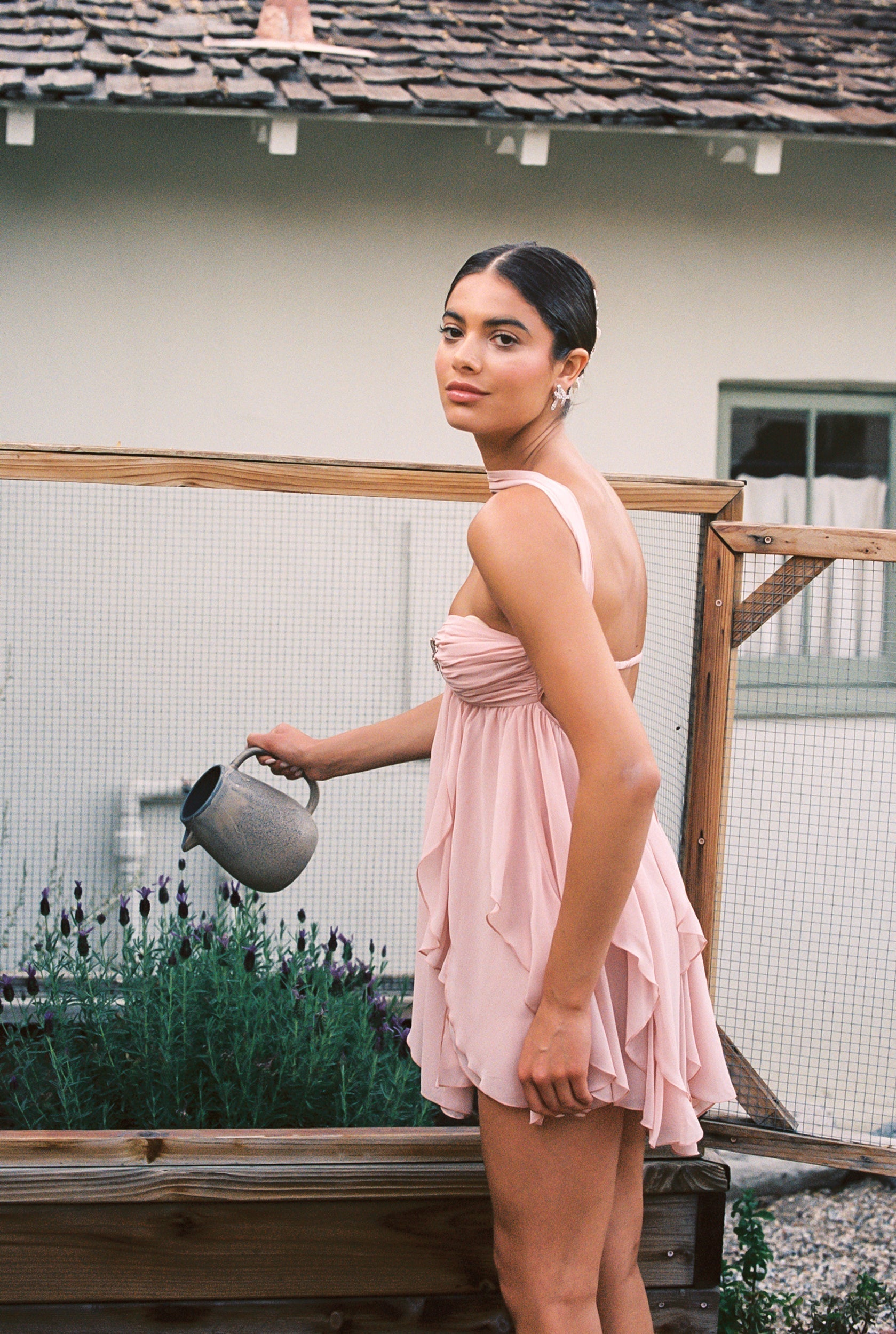 Side profile of the pink Maeve Ruffle Mini Dress with a strapless ruched bodice and cascading ruffles.