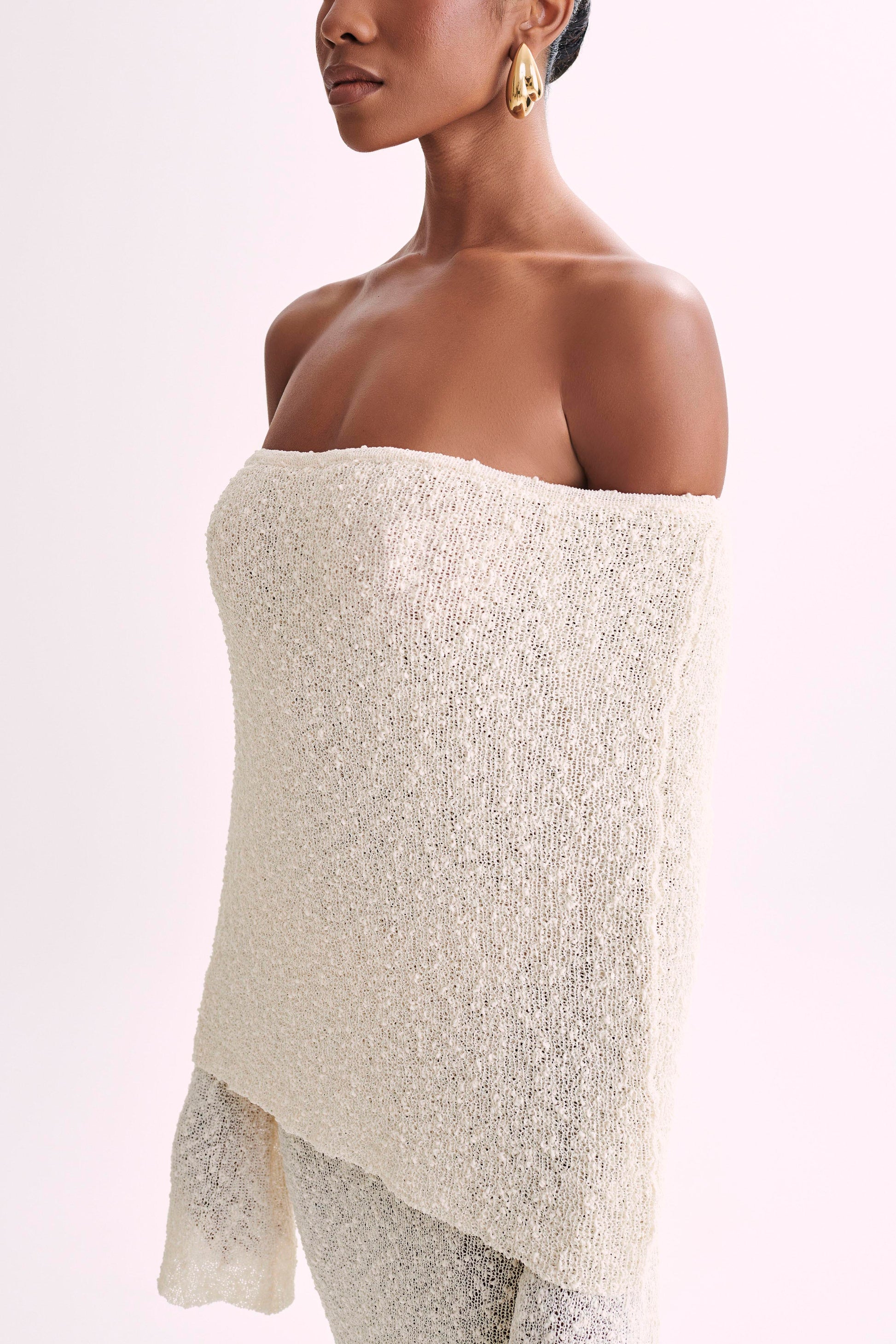 Close-up of the textured cream boucle fabric on the off-the-shoulder maxi dress, showing material detail.