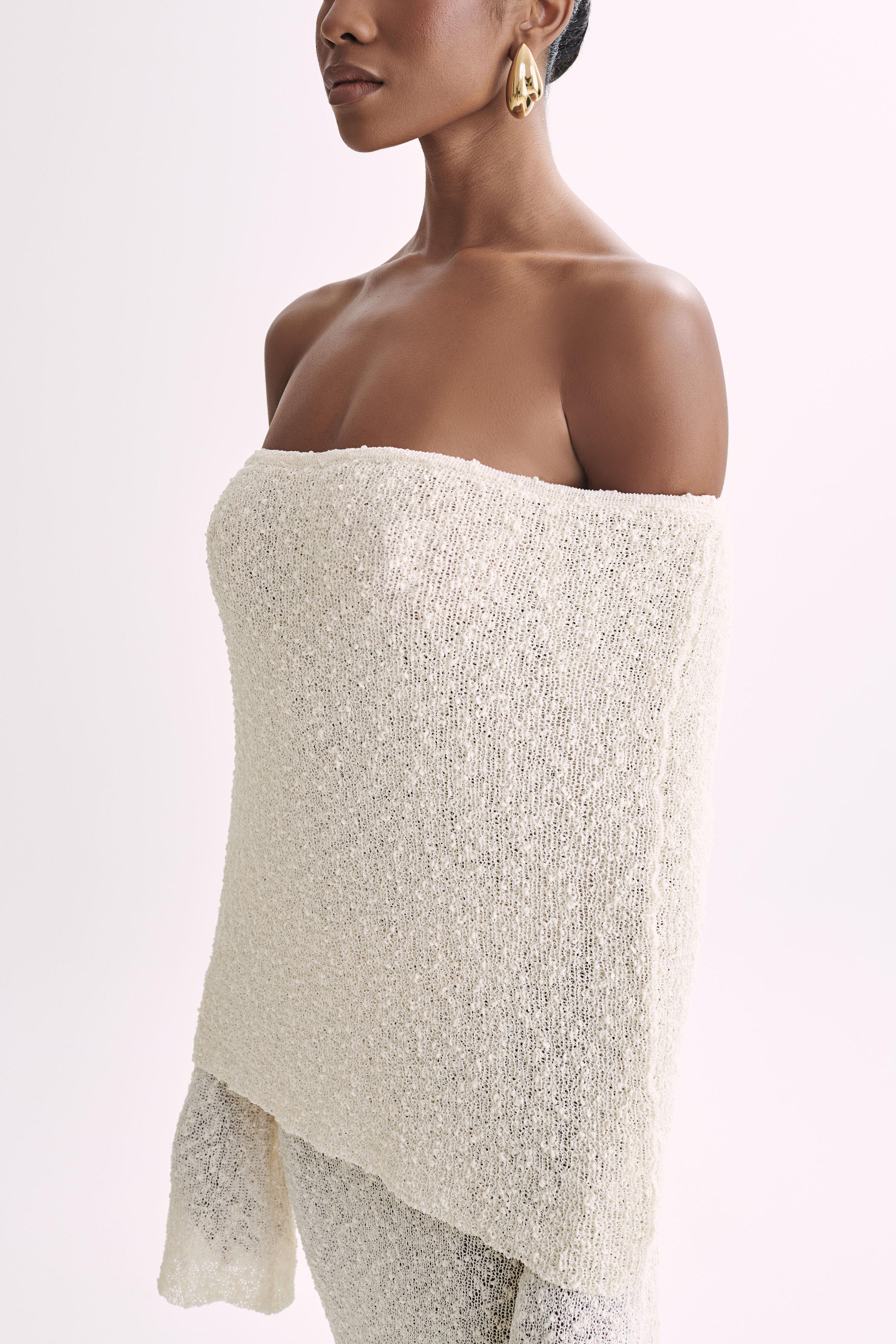 Close-up of the textured cream boucle fabric on the off-the-shoulder maxi dress, showing material detail.